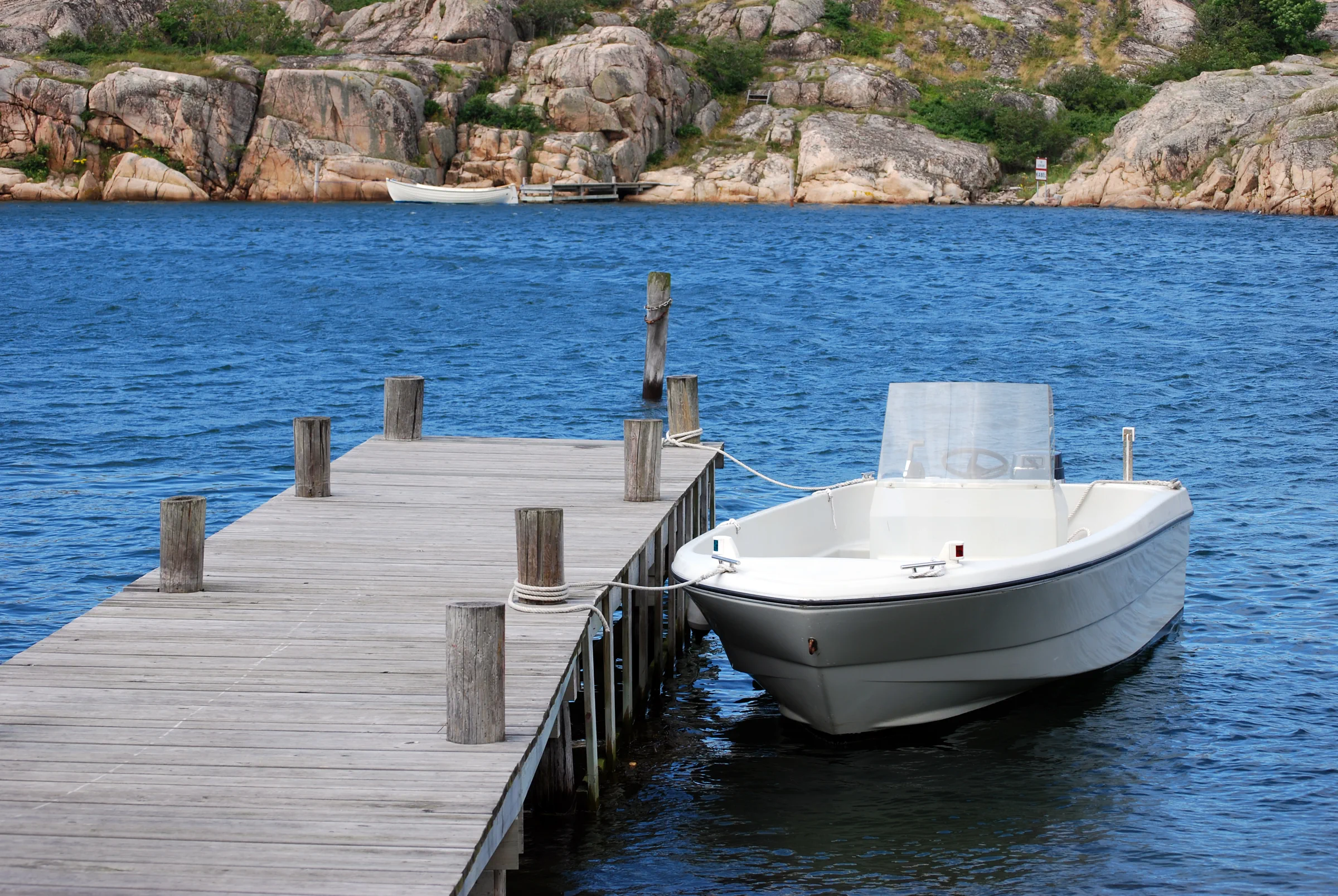 Small motorboat docked at a wooden pier